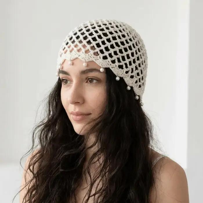 Bonnet en tricot ajouré au crochet avec pompons et perles