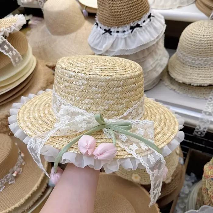 Chapeau de paille à large bord avec nœud en dentelle et fleur